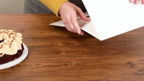 Putting Cake in Cake Box on Wooden Table