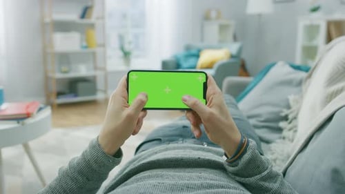 Person Lying on Sofa Using Chroma Key Mobile Phone