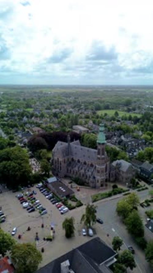 A stunning aerial view of a European town with a historic church and green fields stretching