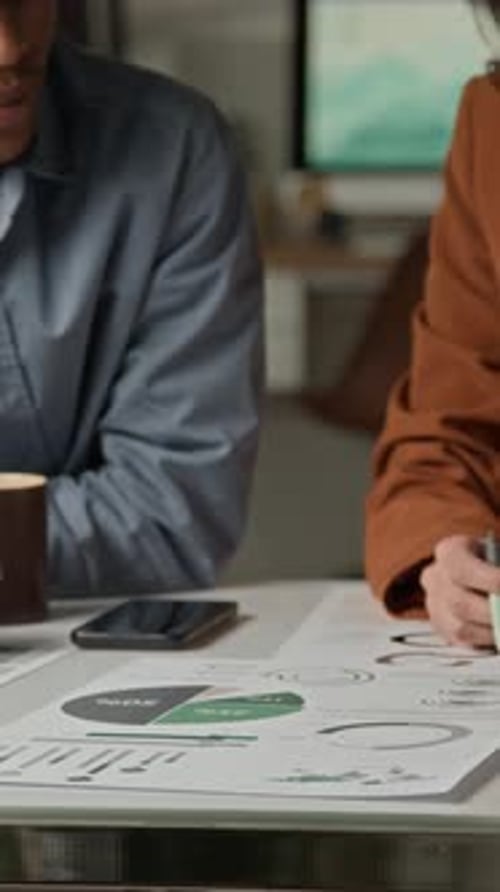 Coworkers Reviewing Data Chart on Paper