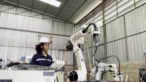Woman Operating Welding Robot in Modern Factory