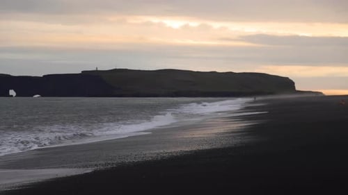 Gorgeous wide shot of waves crashing on shore at the Reynisfjara Black Sand Beach, Iceland.