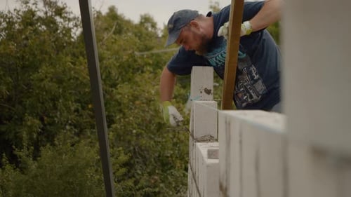 Construction Worker Building a Wall Outdoors in Daytime