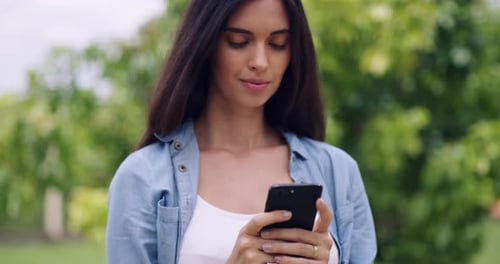 4k video footage of a young woman using a mobile phone in a park