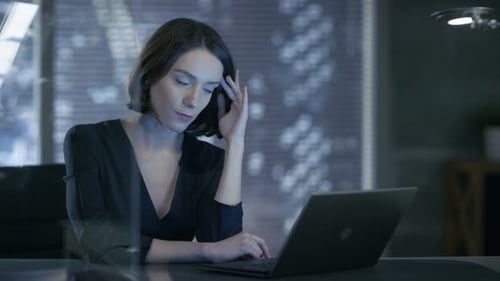 Female Executive Works on a Laptop in Her Private Office with Big City View. She's Solving Problems