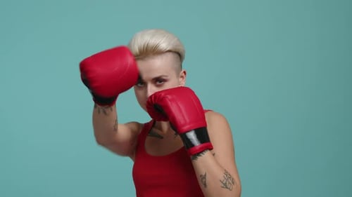 Woman Practices Punching with Red Boxing Gloves