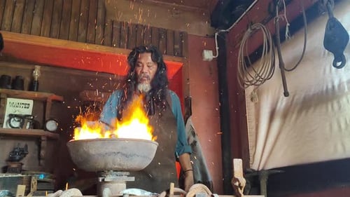 Steel worker amid sparks from molten steel in industrial foundry