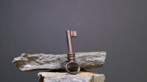 Antique Key on Black Stone. Camera Rotates Around Padlock