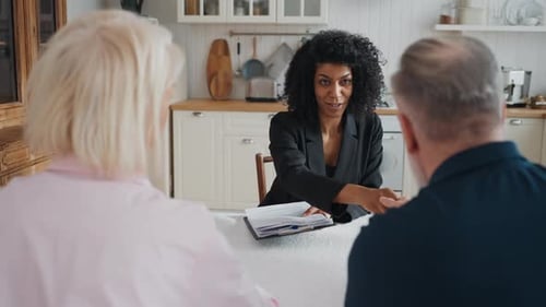 Real Estate Manager Meeting with Elderly Couple in New House Discuss Contract Positive African