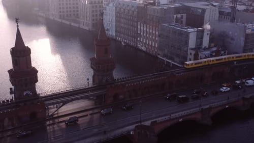 Historic Oberbaum bridge with yellow subway on track crossing over; aerial