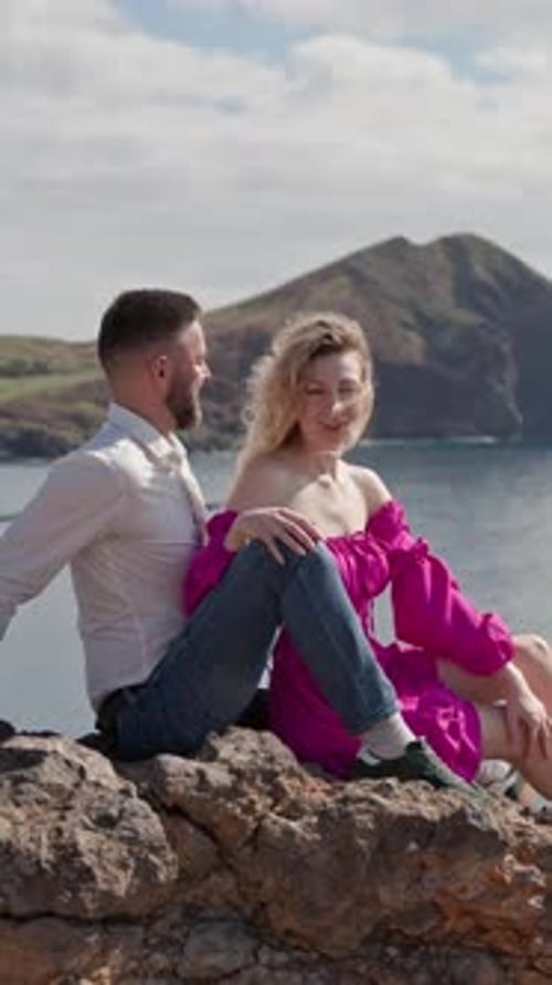Romantic Couple Sitting on Rocks Overlooking Ocean