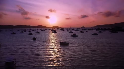 Silhouettes of Yachts Moored in Ocean Bay Surrounded By Mountain Ridge Filmed Against Sunset