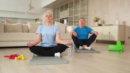 Mature Couple Meditating in Living Room