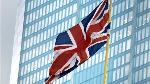 British Union Jack Flag Waving Near Modern Building