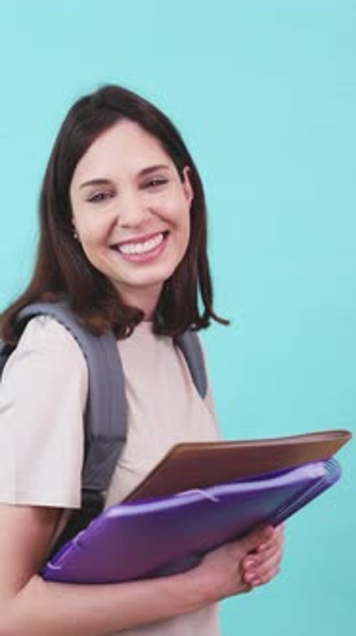 Smiling Student Holding Notebooks in Studio Setting