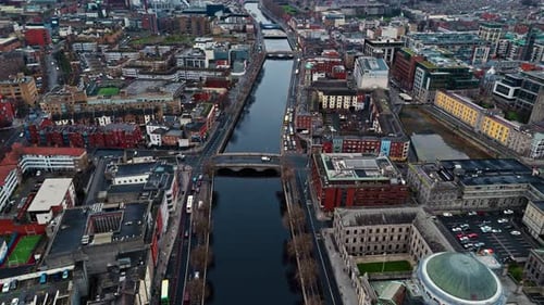 aerial landscape drone shot flying over river Liffey in Dublin City in winter at sunrise