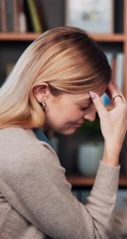 Woman with Headache Massaging Forehead