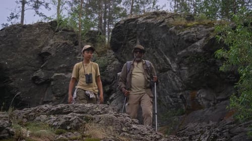 Adult and Teen Hiking Up Rocky Hill
