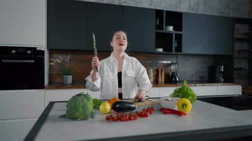 Woman happily preparing fresh vegetables in kitchen