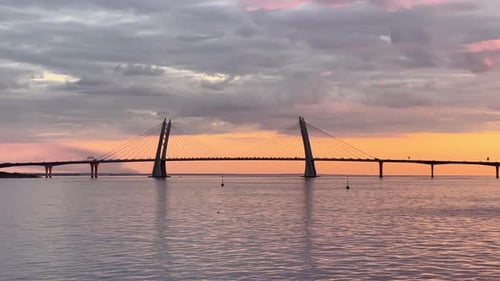 The Cablestayed Bridge at Sunset Car Traffic on the Highway Over Water Magic Reflection on Water