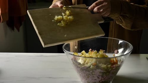 Man cutting potatoes for salad at kitchen