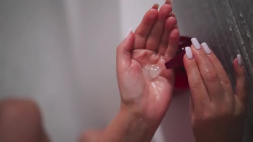 Woman Pumping Lotion in Shower Close Up
