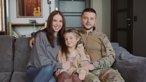 Smiling Family Portrait on Gray Couch Indoors