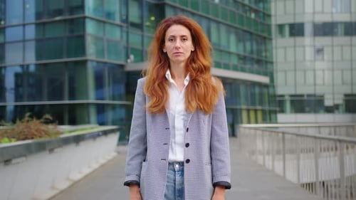 Uma mulher formal Corporativo atraente, confiante, feliz, sorridente, diversificada, em frente a um escritório