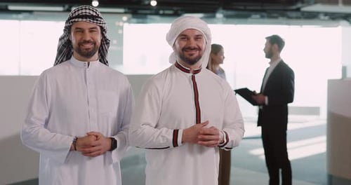 Mulsim Couple of Arabian Young Adults Businessmen Wearing White Kandura Crossing Their Arms Smiling
