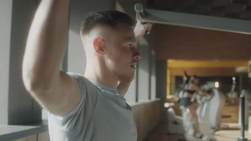 Man Exercising with Lat Pulldown Machine in Gym