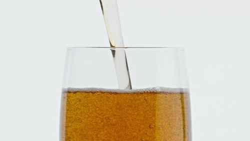 Pouring Refreshing Brown Beverage into a Clear Glass