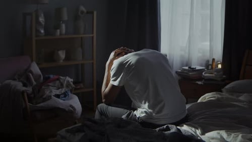 Young Adult Experiencing Stress in a Bedroom