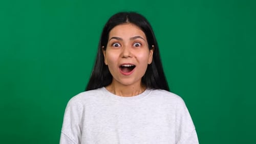 Triumphant Surprise In the Studio a Successful and Shocked Woman Celebrates Victory Displaying a