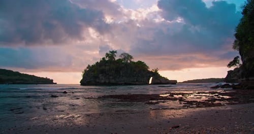 Island Silhouette at Sunset in Shallow Calm Ocean Water with Dark Cloudy Colorful Sky on Crystal Bay