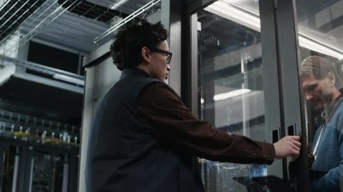 Team of Network Engineers Managing Hardware Inside Data Center Server Room