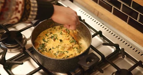 Person Stirring Creamy Vegetables in a Pot
