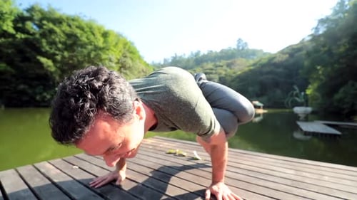 Man Doing Yoga Pose on Wooden Dock