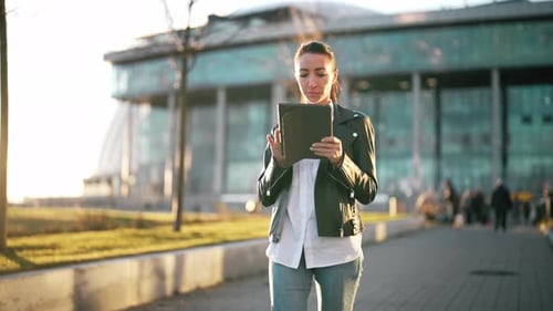 Portrait of Young Happy Smiling Woman Walking with Digital Tablet in Hands on Outdoors Nature