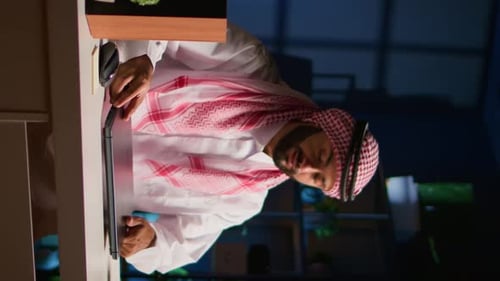 Man Working on Laptop in Modern Office at Night