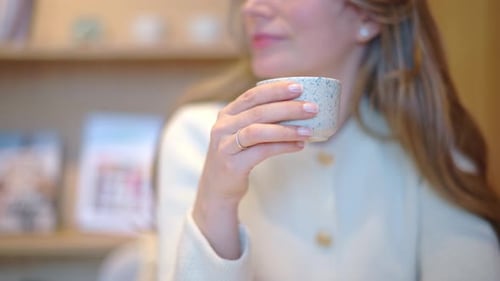 Woman drinking latte art coffee from ceramic cup in a cafe