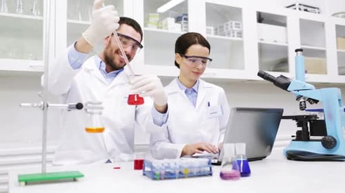 Science, Chemistry, Technology, Biology and People Concept - Young Scientists with Pipette