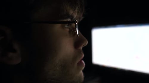 Young Trader Working on Computer at Night Male Financial Analyst Looking at Foreign Exchange Charts