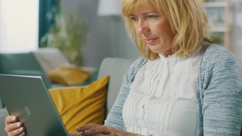 Woman Using Laptop Computer at Home on Couch