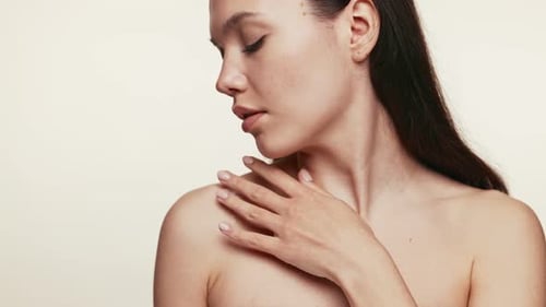 Femme sereine appliquant une crème hydratante sur les épaules et le cou