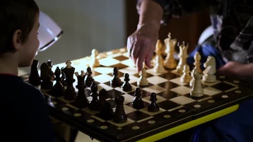 Großmutter spielt zu Hause mit ihrem Enkel Schach, Nahaufnahme, Zeitlupenaufnahmen, gedrehtes Video