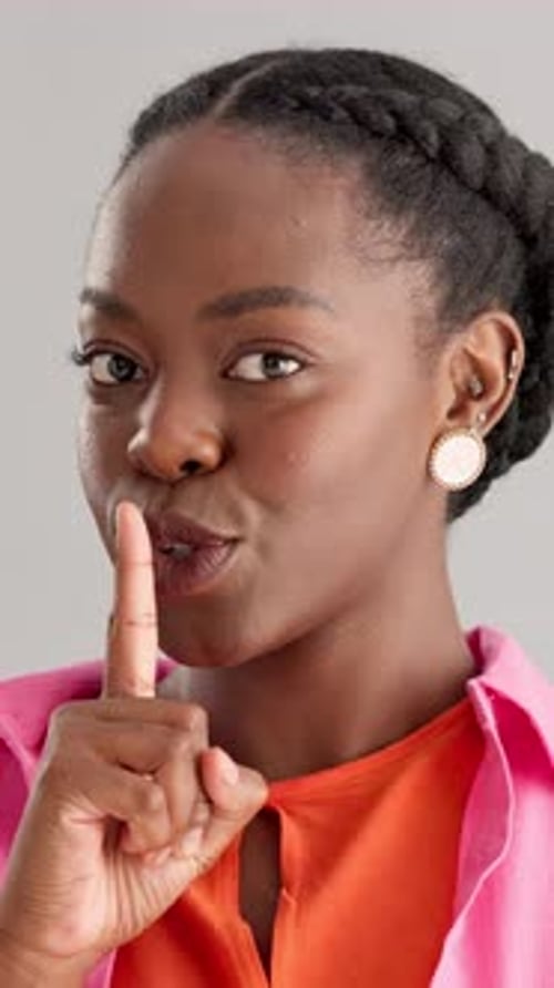 Black woman, face and quiet finger in studio, confidential privacy and background gossip