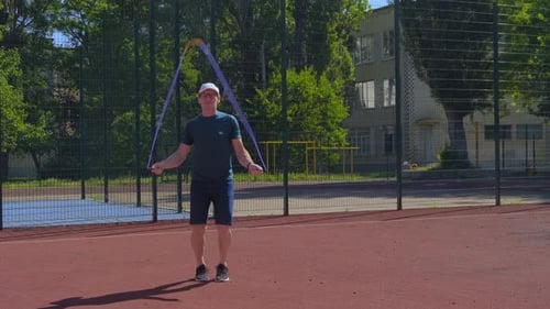 Man Exercising, Jumping Rope Outdoors on Sunny Day
