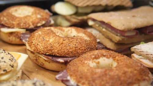 Eine köstliche Auswahl an Bagels und Sandwiches, perfekt angerichtet auf einer schönen Holzplatte