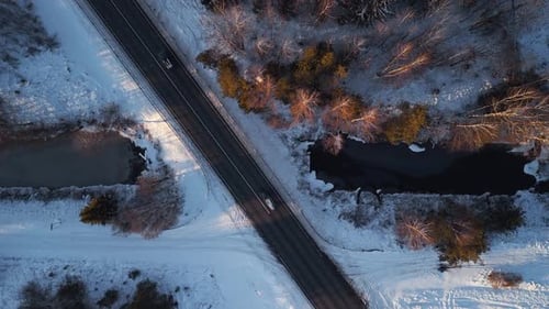 A Stunning Aerial View Capturing a Beautiful Snowy Landscape Featuring a Road and a Stream with