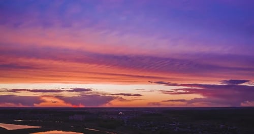 Orange Sunset and Purple Clouds Over Town